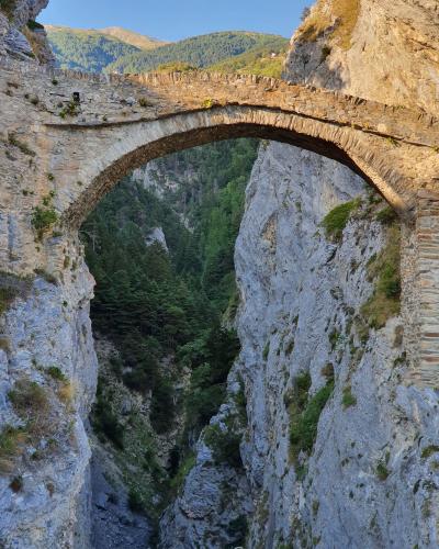 Ancient stone bridge over a picturesque gorge in Leuk, Switzerland, showcasing natural beauty and historic architecture.