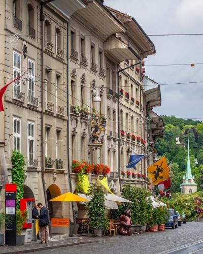 Vibrant scene of a historic street in Bern, Switzerland, showcasing beautiful architecture and lively atmosphere.