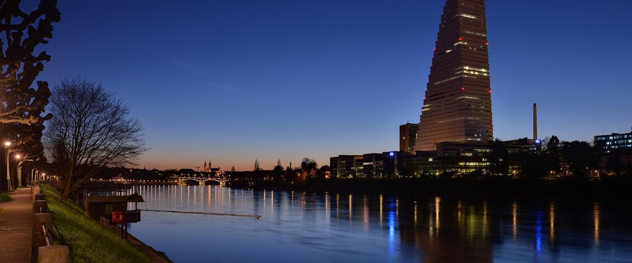Basel - Roche-Turm mit Stadtansicht bei Abenddämmerung