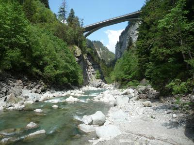 The Hinterrhein flowing over boulders at the bottom of the Viamala gorge, spanned by a high bridge