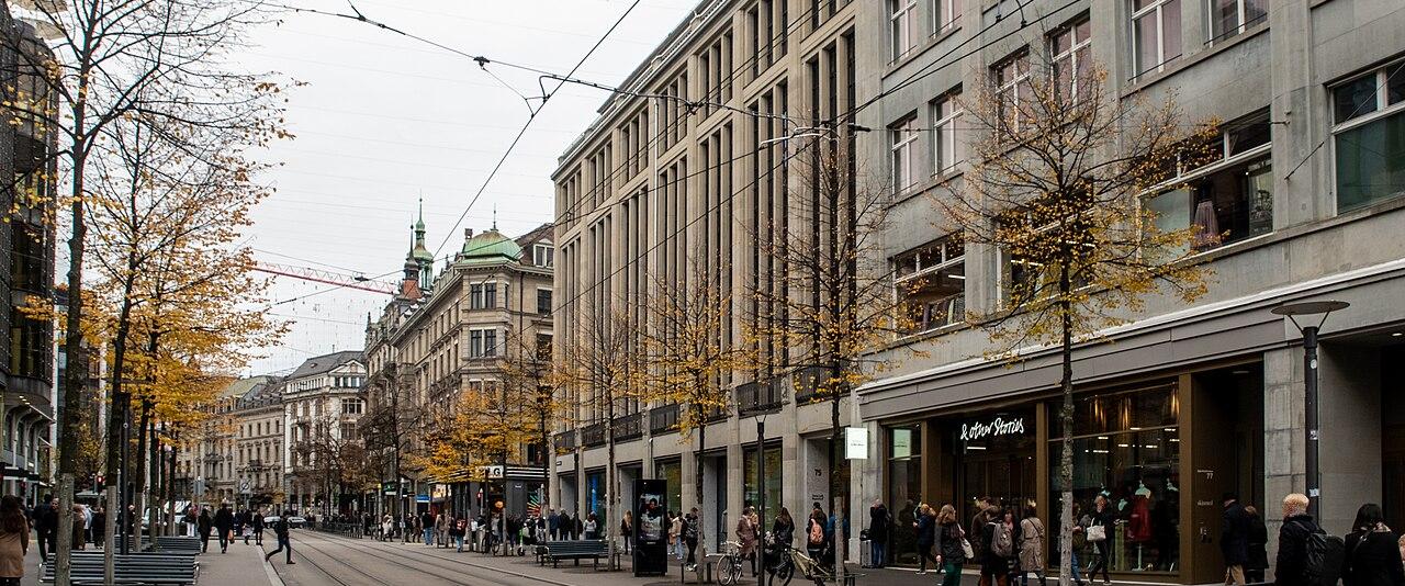 Bahnhofstrasse in Zurich with department stores, tram tracks and shoppers on an autumn day