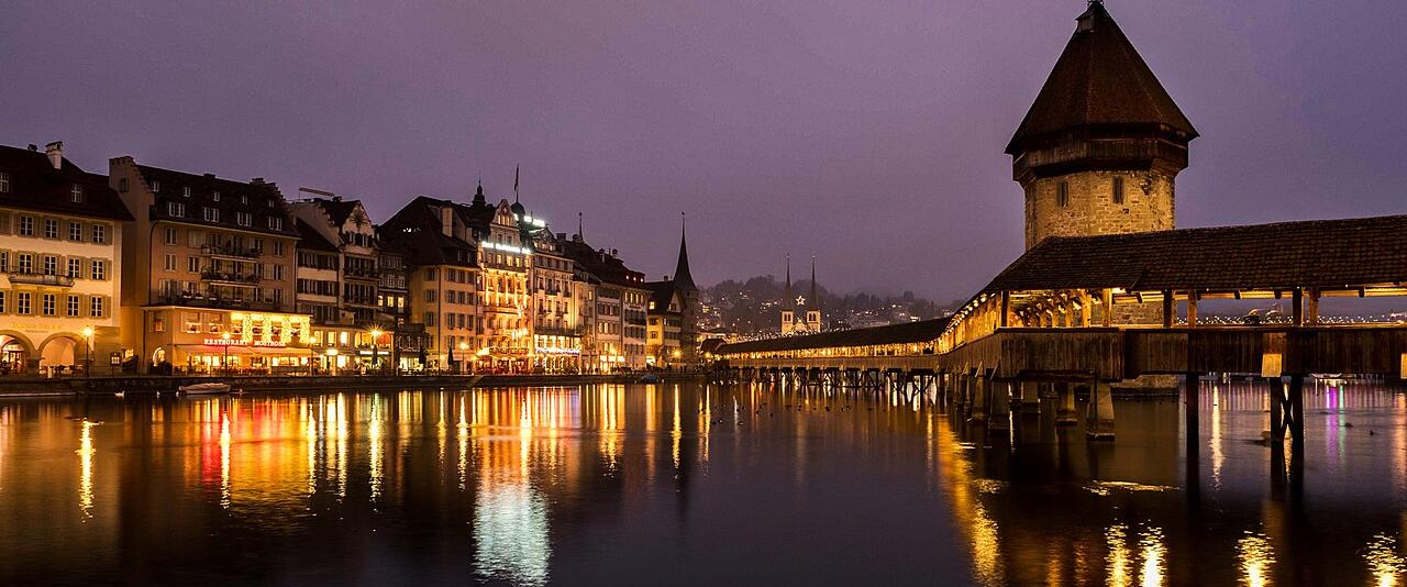 The Chapel Bridge and Water Tower in Lucerne lit at dusk in late December