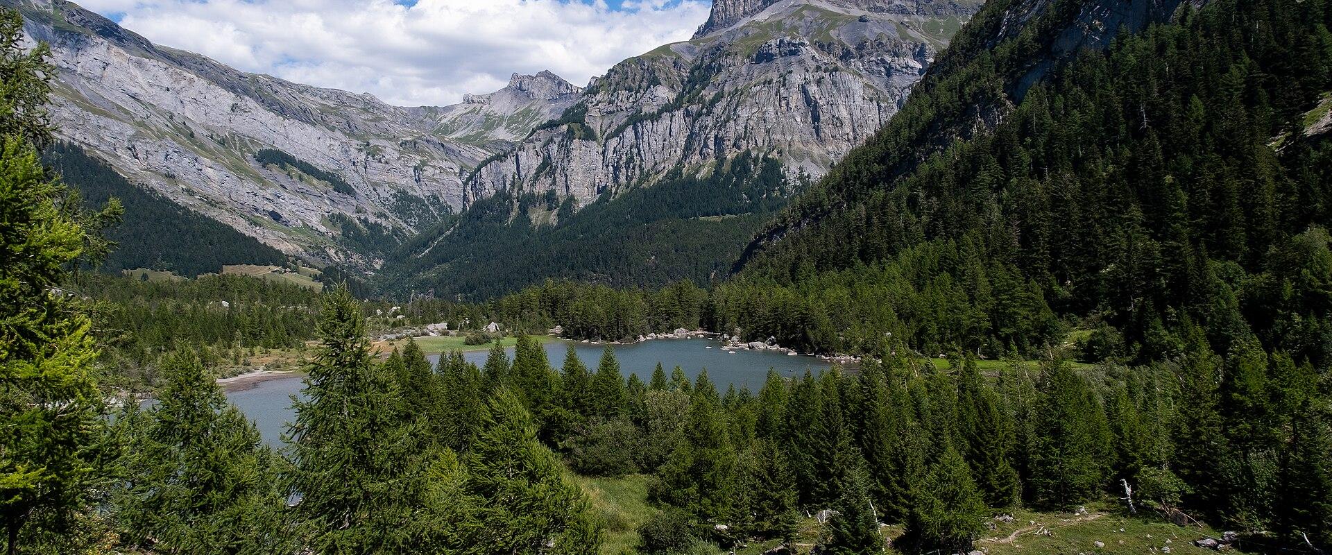 Lac de Derborence among forest and limestone peaks in the Derborence nature reserve, Valais