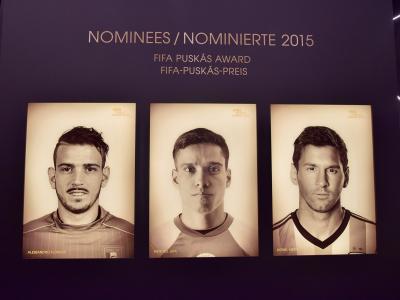 A display wall inside a museum featuring framed portraits of three football players (Alessandro Florenzi, Wendell Lira, Lionel Messi) nominated for the 2015 FIFA Puskás Award, with bilingual signage in English and German ("NOMINEES / NOMINIERTE 20
