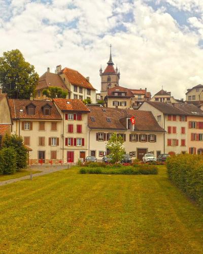 Old town of Estavayer-le-Lac with chateau towers and church rising above tiled roofs
