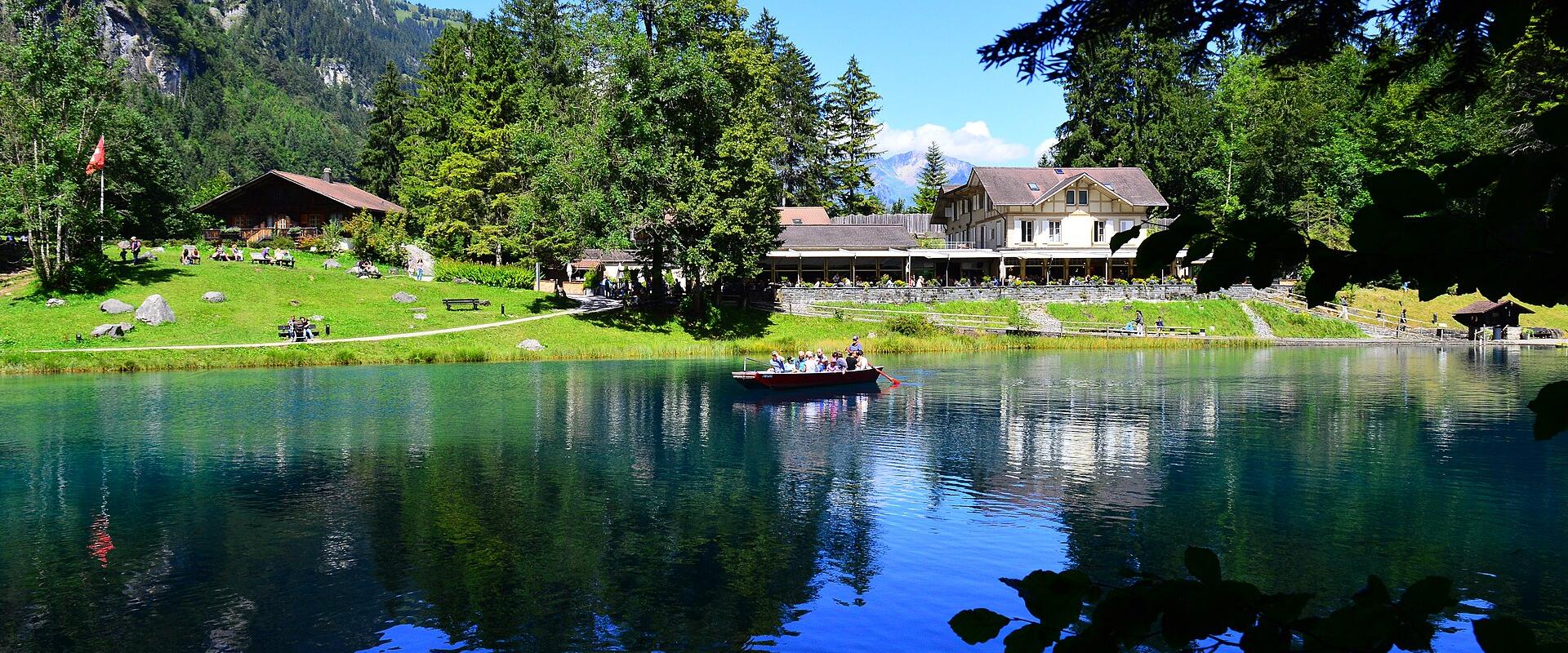 The deep-blue Blausee lake mirrored under forest and mountain slopes