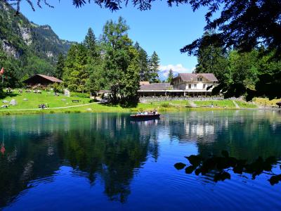 The deep-blue Blausee lake mirrored under forest and mountain slopes
