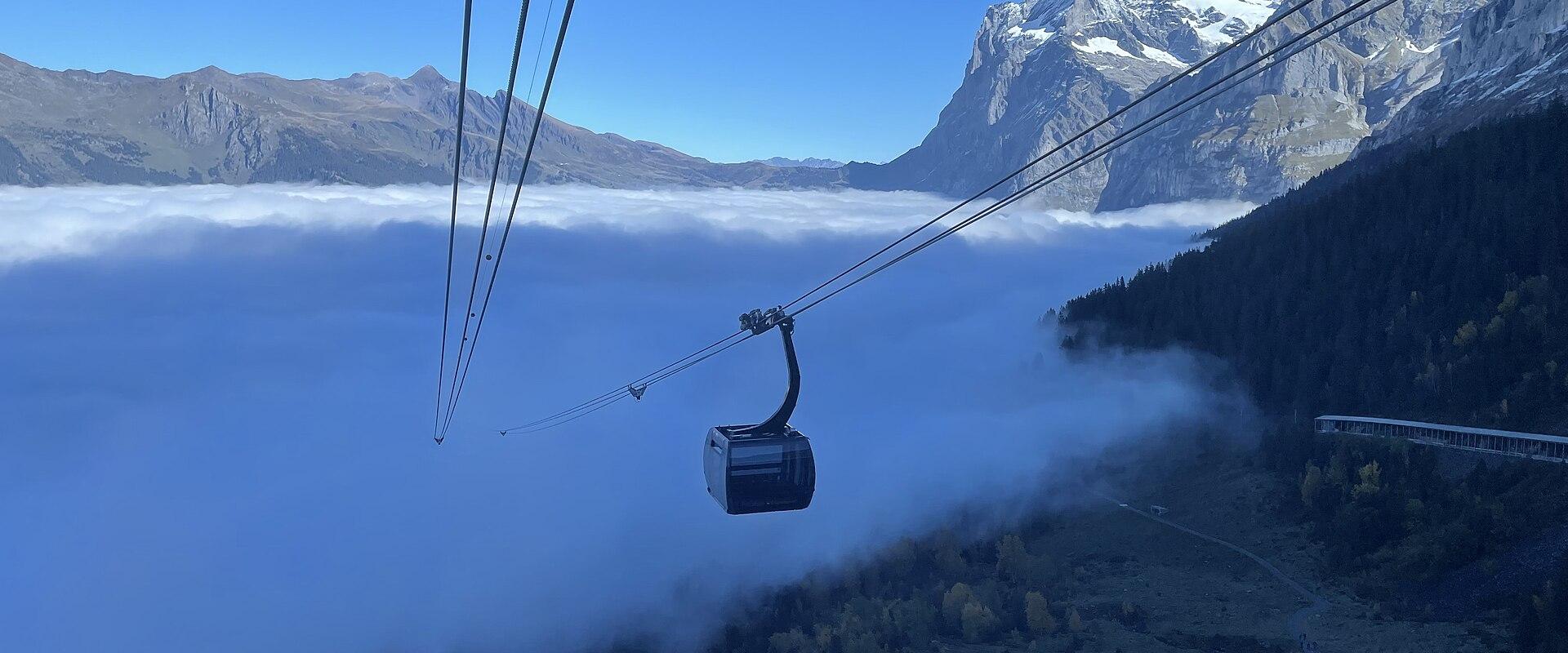An Eiger Express gondola cabin above a sea of cloud near Grindelwald