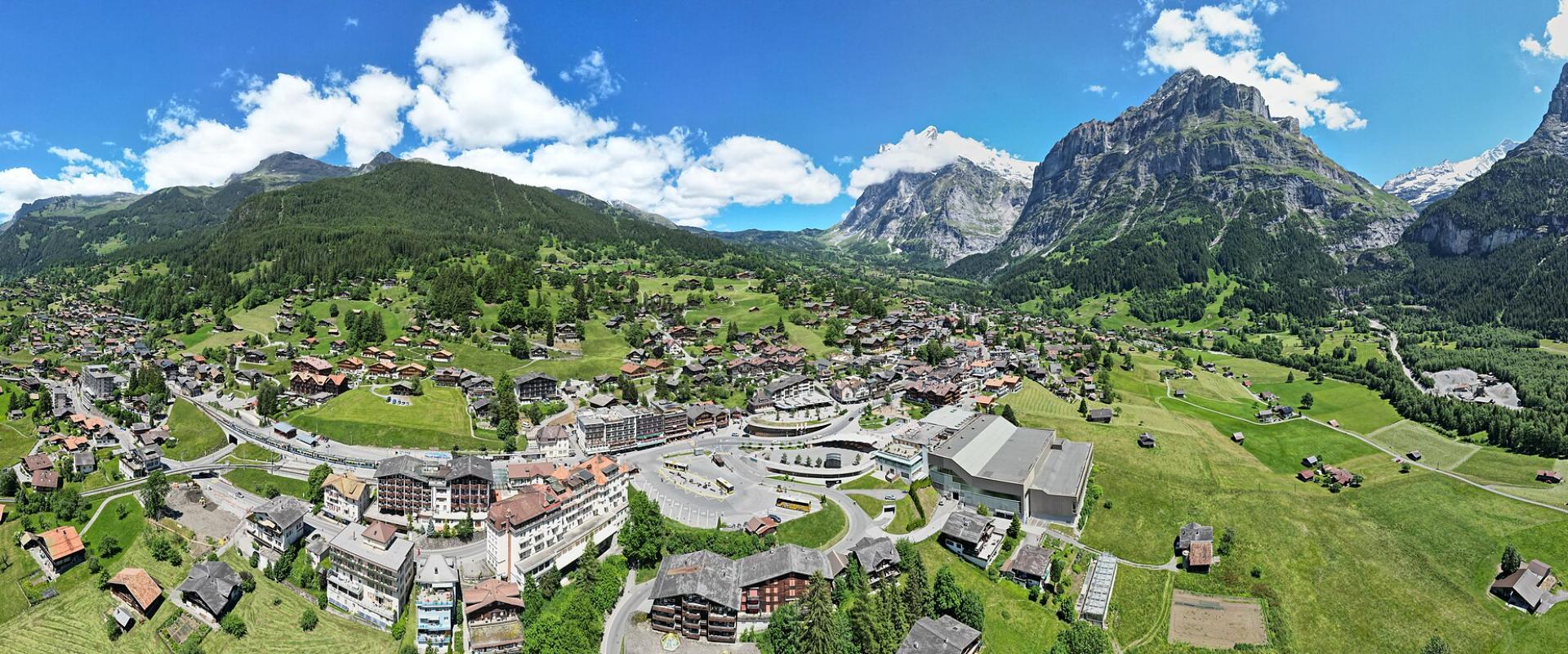 Aerial view of Grindelwald's chalets in the green valley below the mountains