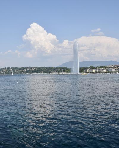 The Jet d'Eau fountain across Lake Geneva with the city's lakefront skyline and the Alps beyond