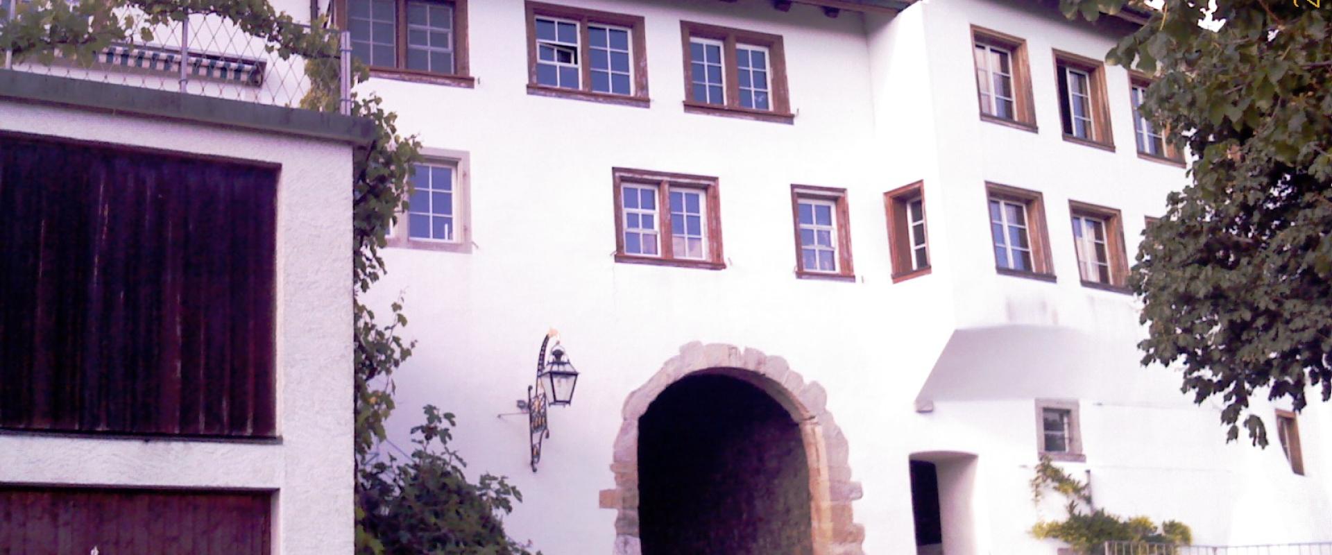 A white building with a stone archway entrance, wooden windows, and a tiled roof, featuring a date stamp of 2009/05/21.