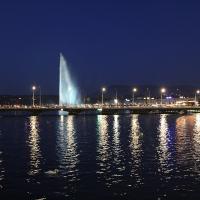 The Jet d'Eau and the lights of Geneva reflected in the lake at blue hour
